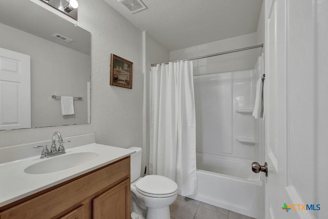 bathroom featuring tile patterned floors, toilet, vanity, and shower / bath combo with shower curtain