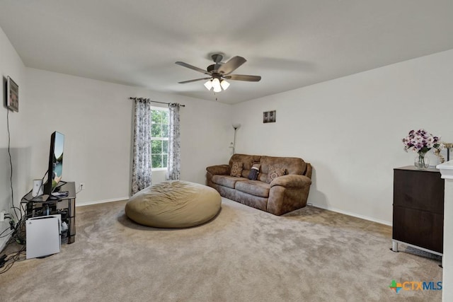 living area featuring carpet floors, ceiling fan, and baseboards