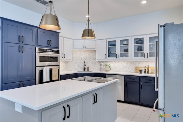 kitchen featuring sink, appliances with stainless steel finishes, backsplash, hanging light fixtures, and a kitchen island