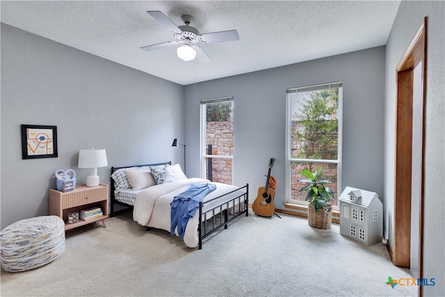 bedroom with ceiling fan, a textured ceiling, and carpet flooring