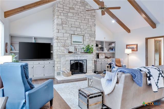 living room with a fireplace, light wood-type flooring, beam ceiling, high vaulted ceiling, and ceiling fan