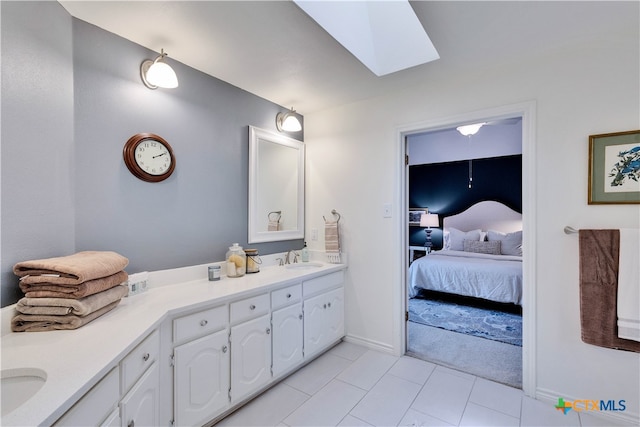 bathroom with tile patterned flooring, vanity, and a skylight