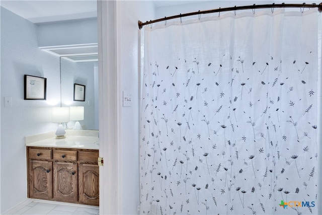 bathroom with curtained shower, vanity, and tile patterned floors