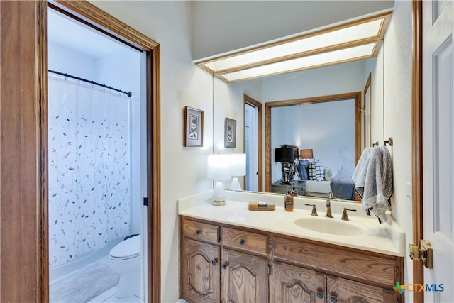 bathroom featuring toilet, vanity, and a shower with shower curtain