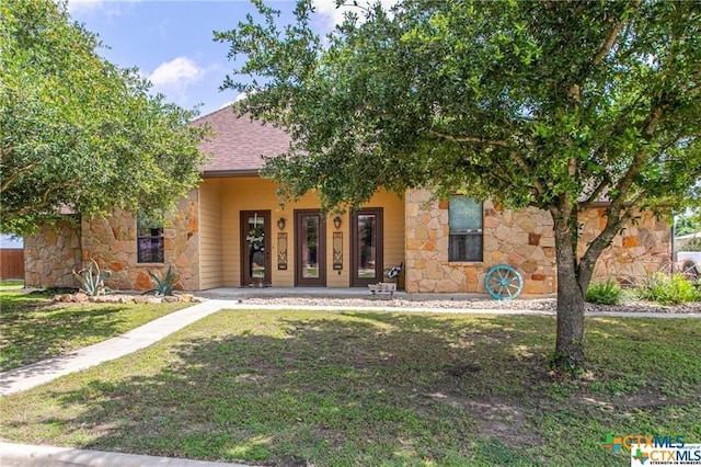 127 Hamer Dr, Salado, TX 76571 - obstructed view of property with stone siding, a front lawn, a shingled roof, and a porch