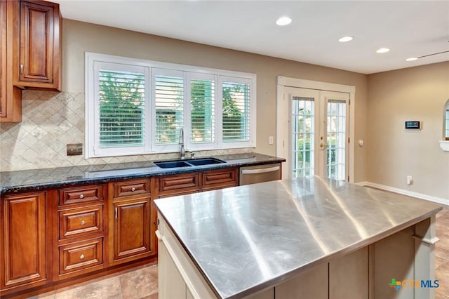 608 Chimney Rock Dr, Victoria, TX 77904 - kitchen featuring stainless steel countertops, a sink, decorative backsplash, brown cabinetry, and french doors