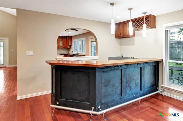 608 Chimney Rock Dr, Victoria, TX 77904 - kitchen with baseboards, a peninsula, a sink, and wood finished floors