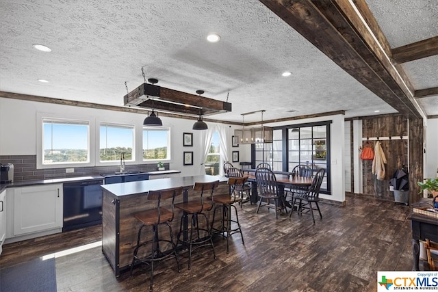 kitchen featuring dark hardwood / wood-style flooring, a textured ceiling, black dishwasher, and a center island