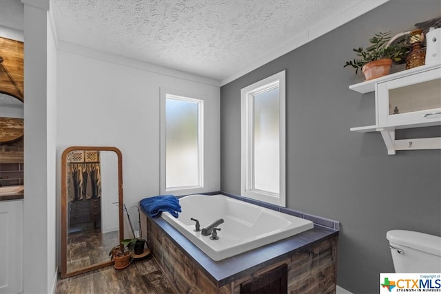 bathroom featuring a bath, hardwood / wood-style flooring, a textured ceiling, and toilet