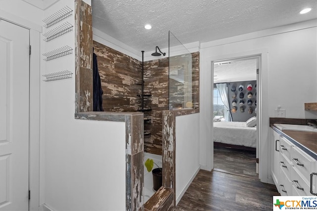 bathroom featuring a shower, vanity, a textured ceiling, and hardwood / wood-style flooring