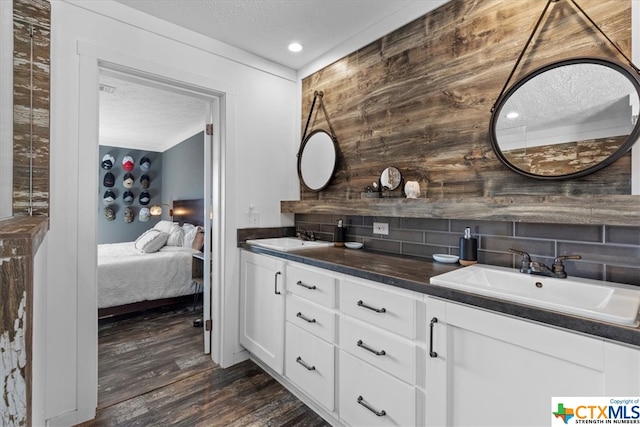 bathroom featuring hardwood / wood-style floors, vanity, and tasteful backsplash