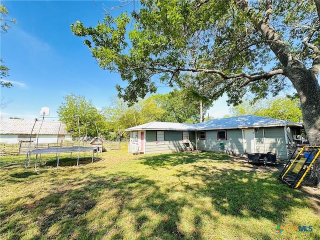 27 County Road 398, TX 77987 - back of property with a lawn, a trampoline, and fence