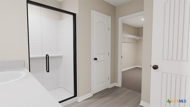 3820 Keller Rd, Temple, TX 76504 - bathroom featuring baseboards, a sink, wood finished floors, and a stall shower