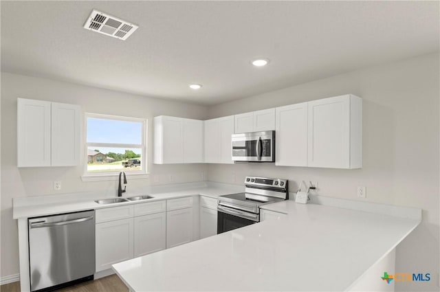 3820 Keller Rd, Temple, TX 76504 - kitchen with appliances with stainless steel finishes, a peninsula, white cabinetry, light countertops, and recessed lighting