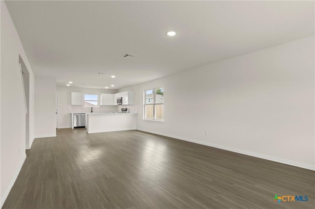 3820 Keller Rd, Temple, TX 76504 - unfurnished living room featuring dark wood-type flooring and recessed lighting
