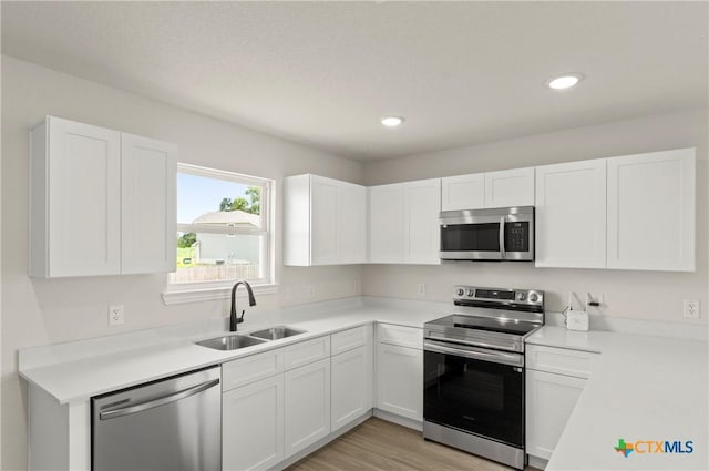 3820 Keller Rd, Temple, TX 76504 - kitchen with appliances with stainless steel finishes, white cabinets, light countertops, light wood finished floors, and recessed lighting