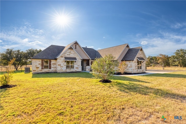 view of front of house featuring a front lawn and central AC unit