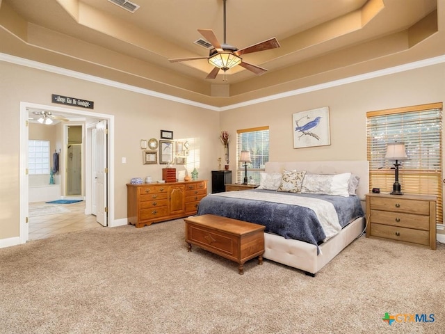 bedroom with ceiling fan, a raised ceiling, crown molding, and light colored carpet