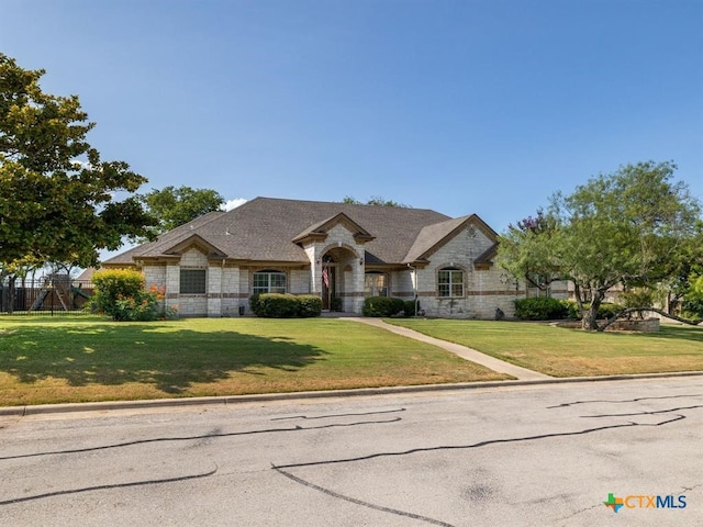 french country inspired facade featuring a front lawn