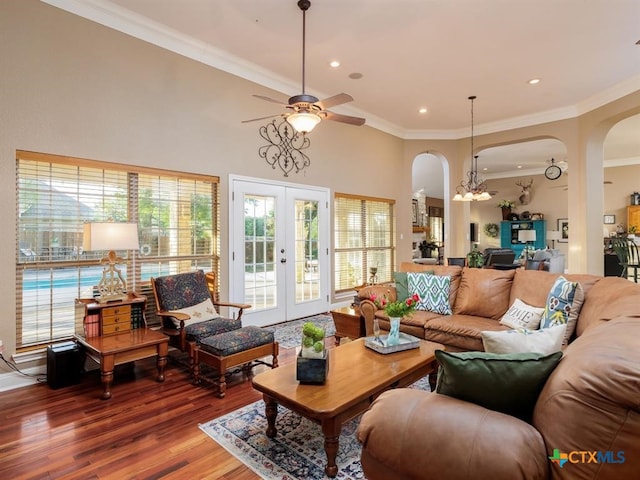 living room with ornamental molding, french doors, ceiling fan with notable chandelier, and wood-type flooring