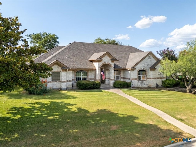 french provincial home with a front lawn