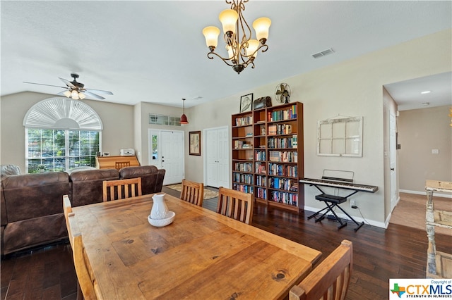 dining space with lofted ceiling, ceiling fan with notable chandelier, and dark hardwood / wood-style floors