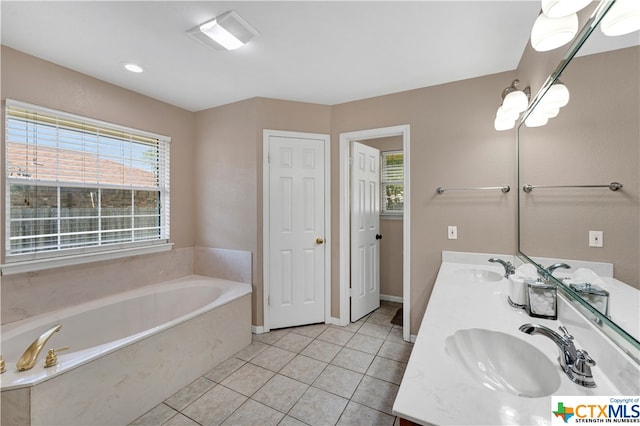 bathroom with tile patterned flooring, vanity, and a tub