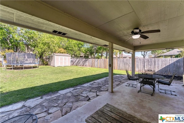 1274 Fox Glen Rd, New Braunfels, TX 78130 - view of patio / terrace with a shed, an outbuilding, ceiling fan, a trampoline, and outdoor dining area