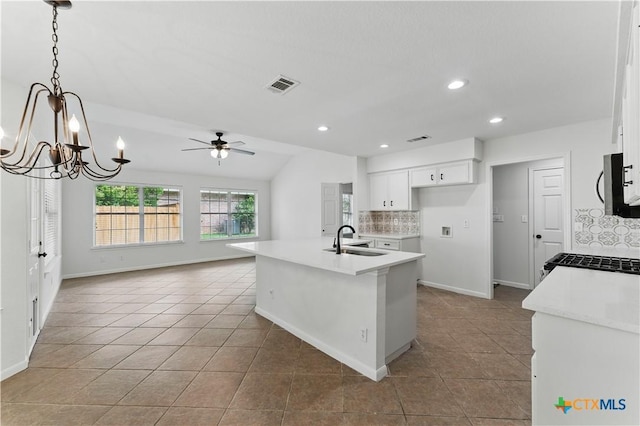 kitchen featuring backsplash, visible vents, tile patterned floors, and a sink
