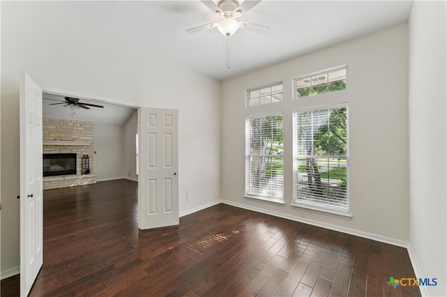 empty room with ceiling fan, baseboards, hardwood / wood-style floors, and a fireplace