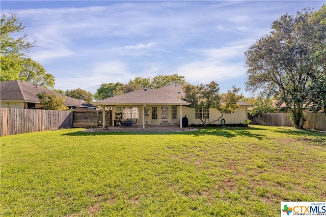 rear view of property with a yard and a patio