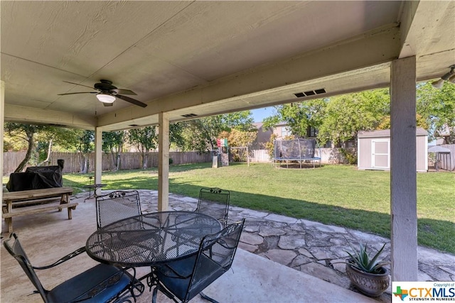 1274 Fox Glen Rd, New Braunfels, TX 78130 - view of patio with a trampoline, a storage unit, a playground, outdoor dining space, and a ceiling fan