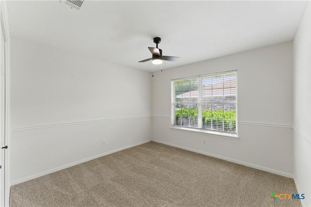 carpeted empty room with ceiling fan, baseboards, and visible vents