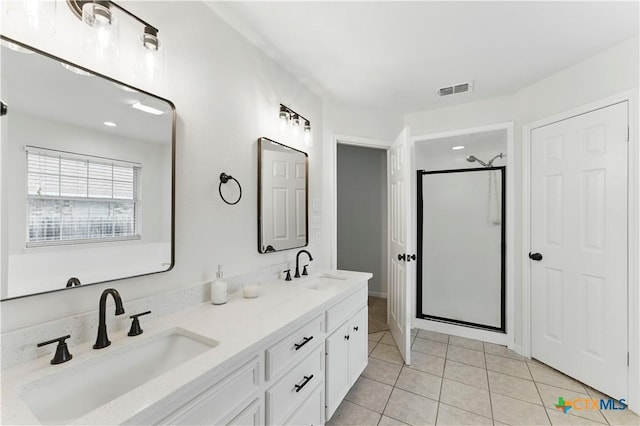 bathroom featuring a shower stall, tile patterned floors, a sink, and double vanity