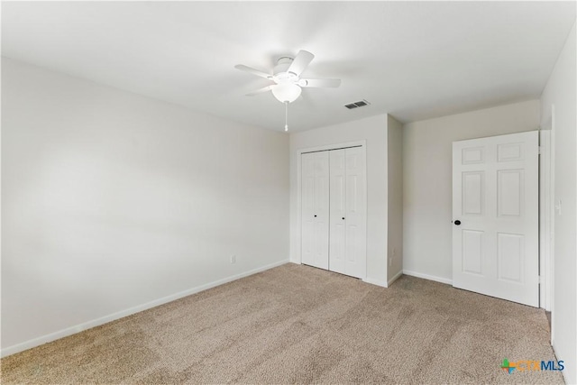 unfurnished bedroom featuring a closet, ceiling fan, baseboards, carpet flooring, and visible vents