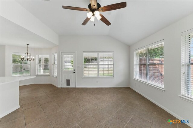 interior space featuring vaulted ceiling, tile patterned flooring, baseboards, and ceiling fan with notable chandelier