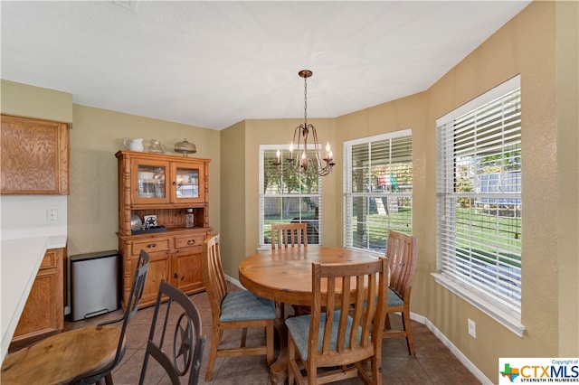 dining space with tile patterned flooring and a chandelier