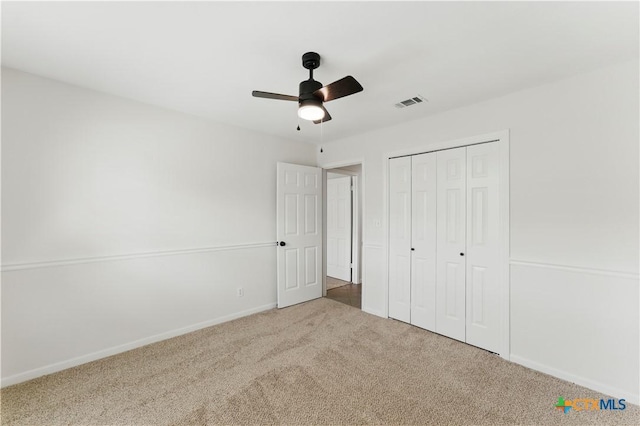 unfurnished bedroom with baseboards, visible vents, a closet, ceiling fan, and carpet floors