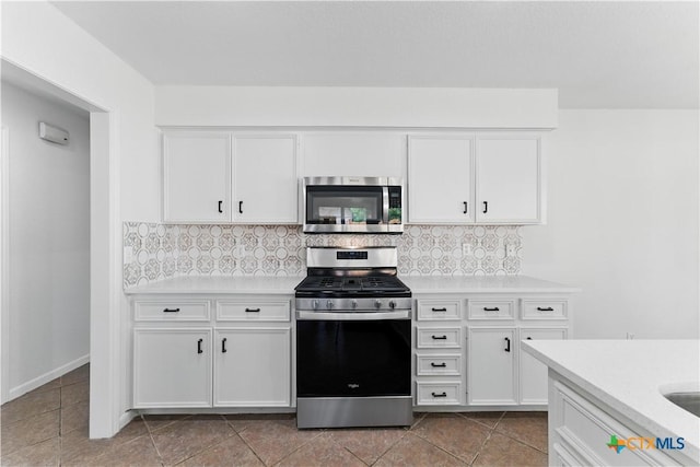 kitchen with light countertops, tasteful backsplash, appliances with stainless steel finishes, and white cabinetry
