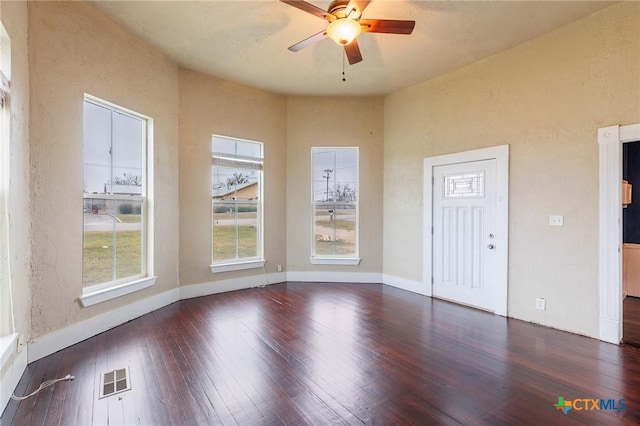302 Avenue N, Marble Falls, TX 78654 - unfurnished room with a textured wall, visible vents, baseboards, a ceiling fan, and dark wood finished floors