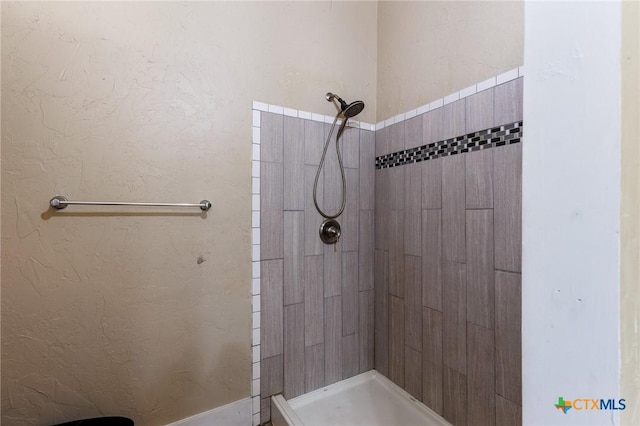 302 Avenue N, Marble Falls, TX 78654 - bathroom featuring a tile shower and a textured wall
