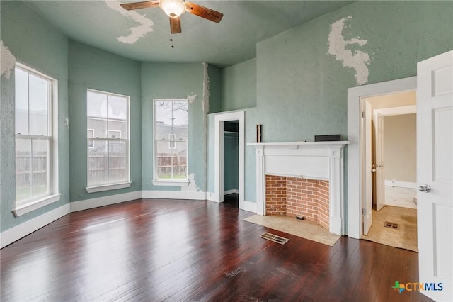 302 Avenue N, Marble Falls, TX 78654 - unfurnished living room featuring ceiling fan, a fireplace, visible vents, baseboards, and dark wood finished floors