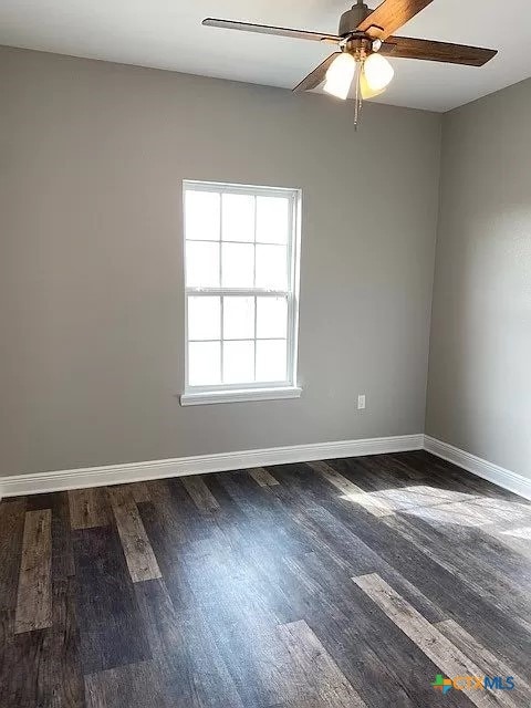 spare room with dark hardwood / wood-style flooring and ceiling fan