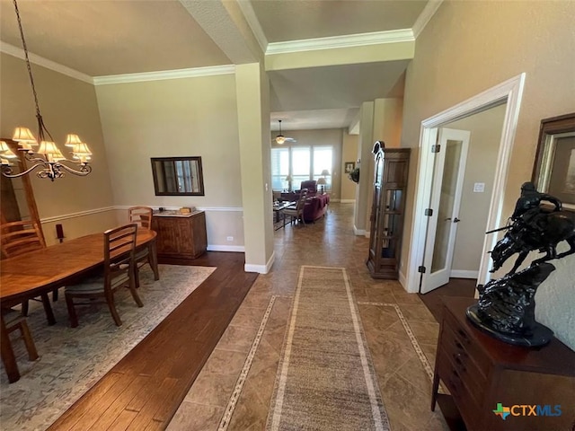 interior space featuring dark wood-style floors, baseboards, ornamental molding, and an inviting chandelier