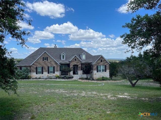 view of front of home featuring stone siding, a chimney, and a front lawn