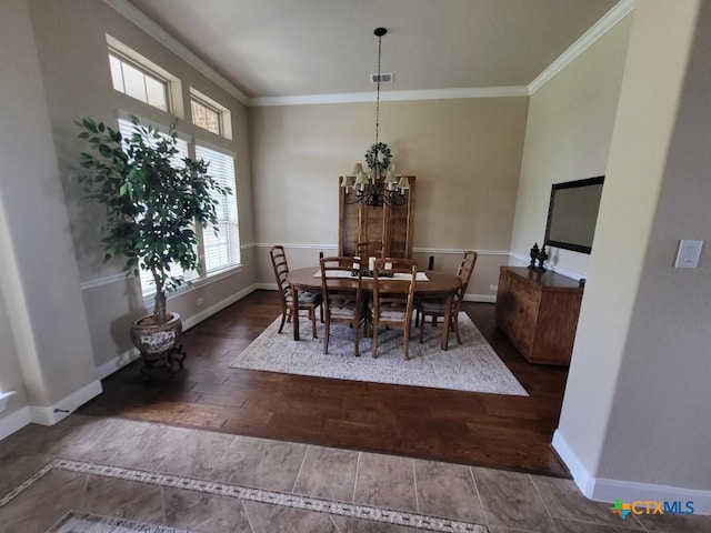 dining room featuring ornamental molding, wood finished floors, visible vents, and baseboards