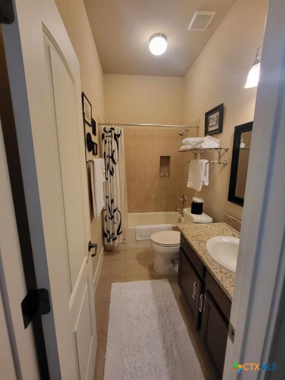 bathroom with visible vents, toilet, shower / bathtub combination with curtain, tile patterned flooring, and vanity