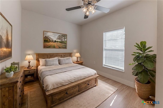 bedroom featuring lofted ceiling, ceiling fan, light wood-style flooring, and baseboards