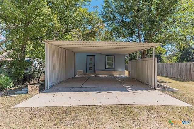 view of outdoor structure featuring fence and driveway