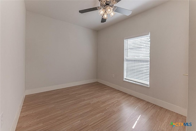 unfurnished room featuring ceiling fan, wood finished floors, and baseboards